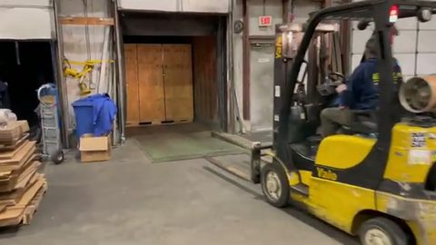 forklift with load backrest at an indoor loading dock